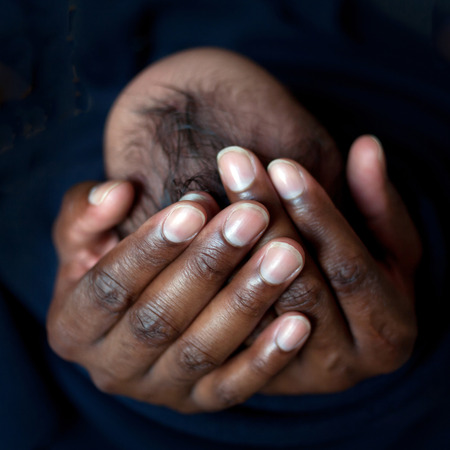 Black father holding newborn baby's head in his handsの写真素材