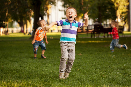 Group of kids playing in an urban neighborhood with bubbles.の写真素材