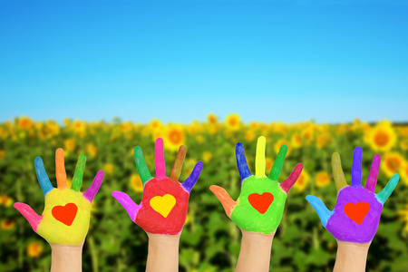 Helping hands with hearts on the palms against nature background. The eco friendly concept.の写真素材