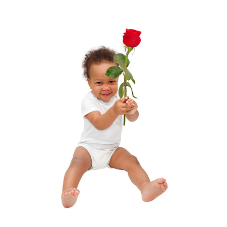 Smiling black baby gives a flower. Mother's Day or Father's Day concept. Isolated on white backgroundの写真素材