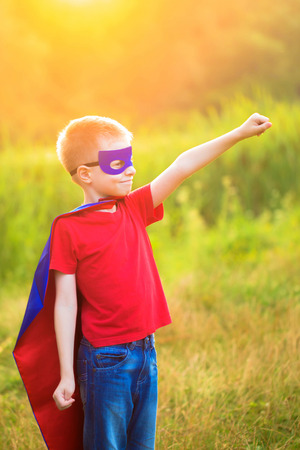 Child playing and portraying super hero and super man outdoorsの写真素材