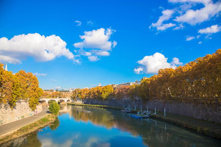 Autumn city landscape. Trees with yellow leaves, river, blue sky with clouds. Sunny autumn day.の写真素材