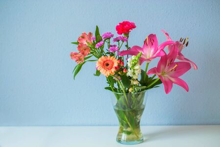 Summer bouquet of colorful different flowers. A bouquet in a vase is on the table.の写真素材