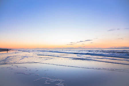 Sandy beach in winter. North Sea at sunset. The tide.