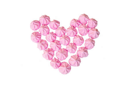 Heart frame made of airy pink cookies meringues. Valentine's day concept. Isolated on white background.の写真素材
