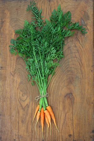 Bunch of fresh carrot on a wooden background. Closeupの写真素材