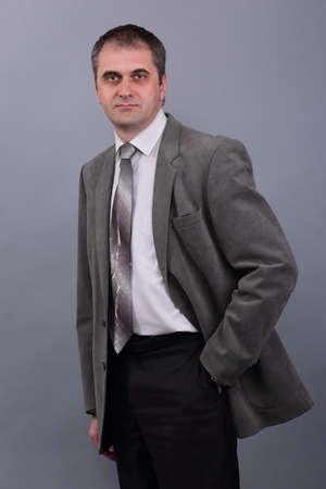 Man in grey jacket on grey backgroundの写真素材