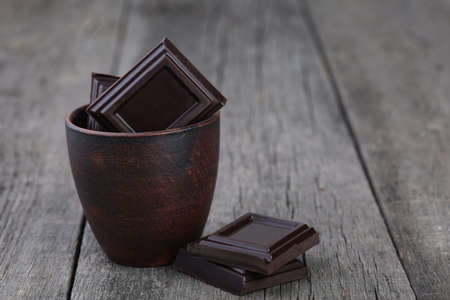 Chocolate in ceramic pot on gray wooden backgroundの写真素材