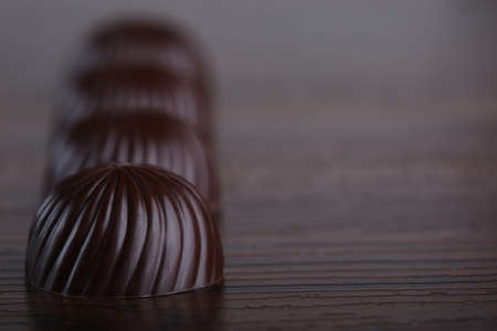 Chocolate candies on wooden background with copy space