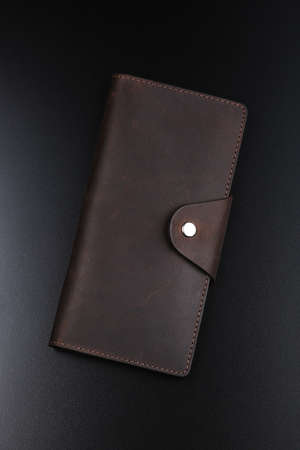 Leather brown wallet on black table. Top viewの写真素材