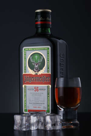 Kropyvnytskyi, Ukraine - 17 November 2020: Bottle of liquerer Jagermeister with glass and ice cubes over gradient black backgroundのeditorial素材