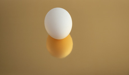 The eggs are white on a Golden background.の写真素材