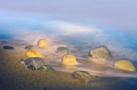 Stones on the beach during sunsetの写真素材