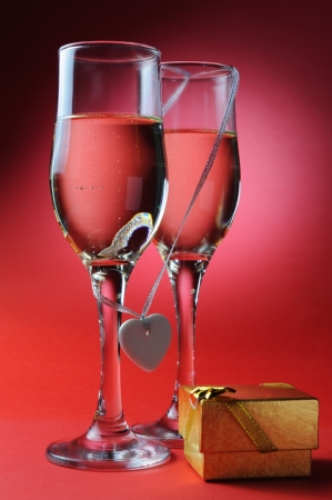 Two wineglasses with heart symbol and gift box, valentine's day conceptの写真素材