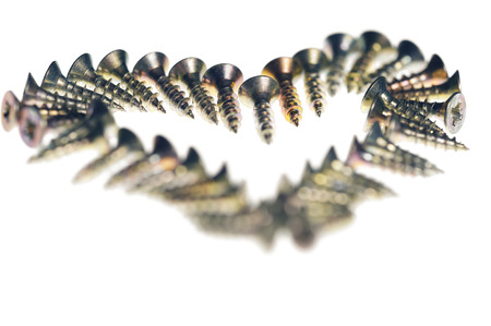 Heart symbol made of screws, isolated on whiteの写真素材
