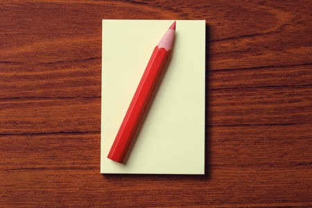 Paper and  red pencil on wood backgroundの写真素材