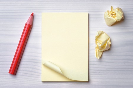 Paper and  red pencil on wood background  Turn over a new leafの写真素材