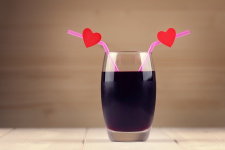 Cherry juice glass with red hearts as a kissing lipsの写真素材
