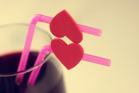 Cherry juice glass with red hearts as a kissing lipsの写真素材