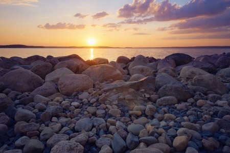 Beautiful landscape, rocks in lake against sunsetの写真素材