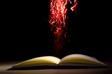 Open book with magic lights on dark background