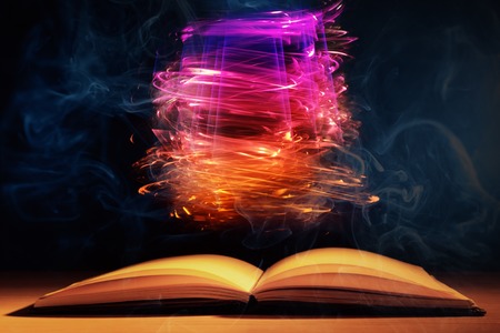 Open book with magic lights on dark backgroundの写真素材