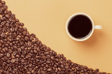 Cup of coffee on coffee beans background style toned