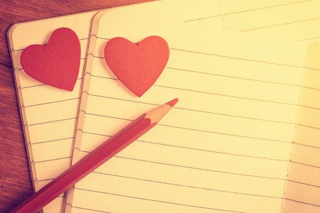 Close up of open notebooks with red hearts and pencilの写真素材