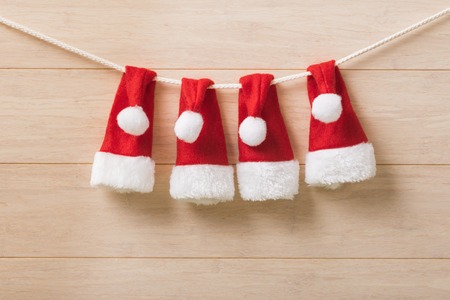 Santa hats on a rope on wooden backgroundの写真素材