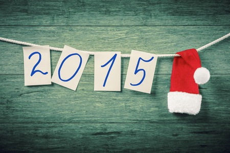 Pages on the rope with 2015 digits and santa hat against wooden backgroundの写真素材