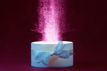 Open holiday box with magic light on dark background