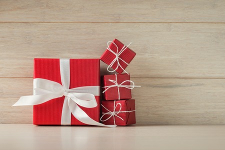 Big and small red gift boxes on wooden background