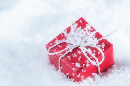 Red gift box in snowflakesの写真素材