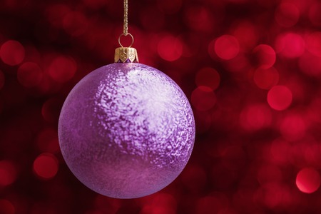Christmas ball against red defocused lights backgroundの写真素材