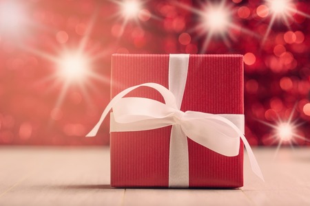 Red gift box against abstract background with star luminous effectの写真素材