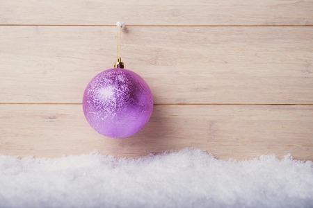 Christmas ball against wooden background with snowの写真素材