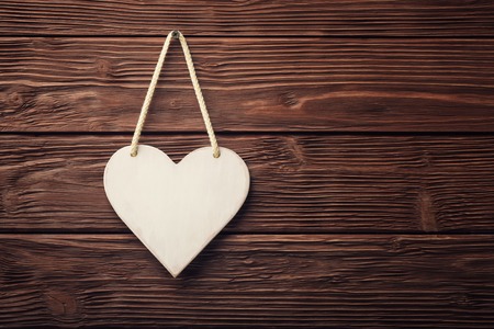 White heart hanging over wooden vintage backgroundの写真素材
