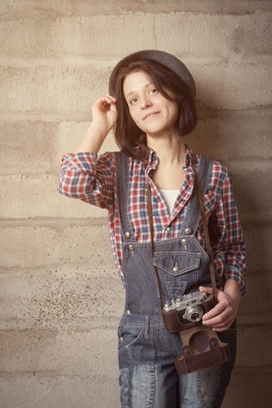 Indoor portrait of woman in a hipster style with vintage cameraの写真素材