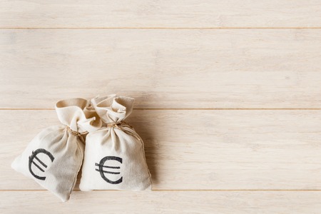 Money bags with euro currency symbol on wooden backgroundの写真素材