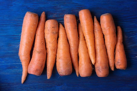Ripe carrot on blue wooden backgroundの写真素材