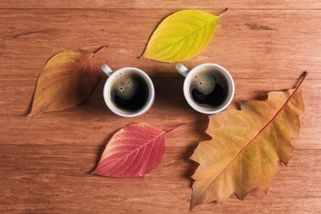 Two cups of coffee with autumn leavesの写真素材