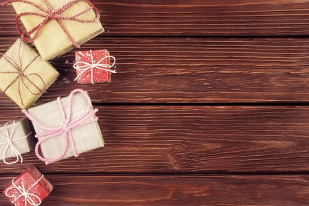 Top view of gift boxes in snowflakes on wooden background