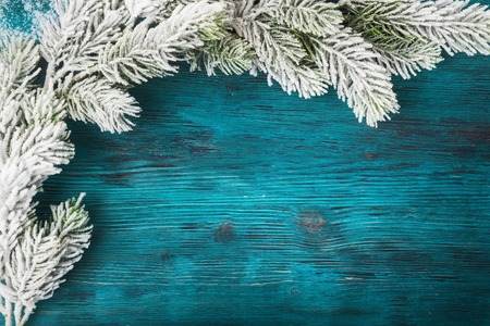 Xmas tree branch over wooden background with copy space