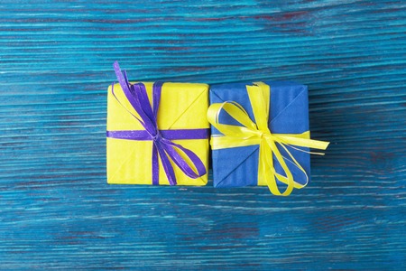 Yellow and blue gift boxes over wooden backgroundの写真素材