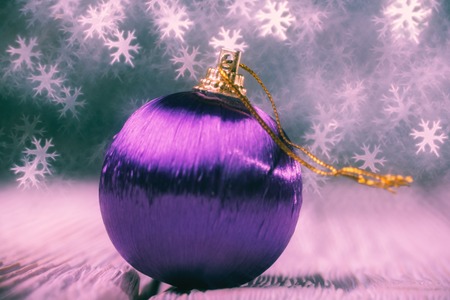 Close up of decorative ball against bokeh in the form of snowflakesの写真素材
