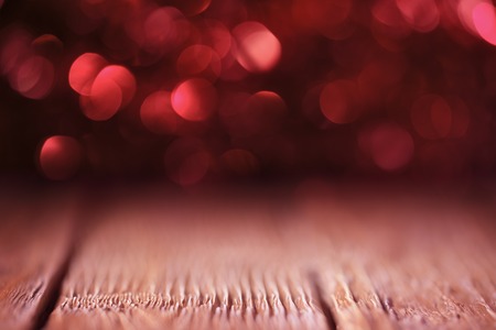Red defocused lights over wooden background. Shallow DOFの写真素材