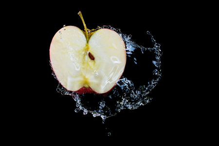 Half an apple in water splashの写真素材