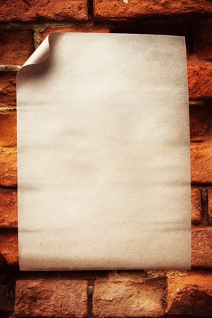 Empty paper sheet over old brick wallの写真素材
