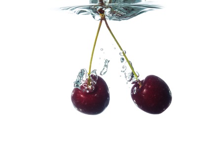Cherry in water splash isolated on whiteの写真素材
