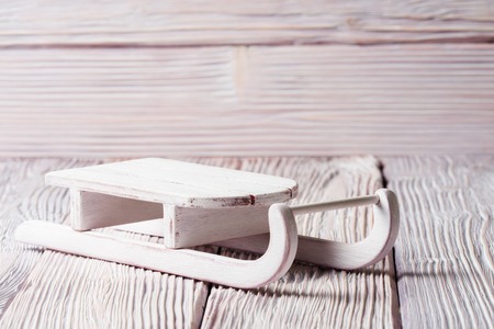 White wooden sledge over light wooden background with copy spaceの写真素材